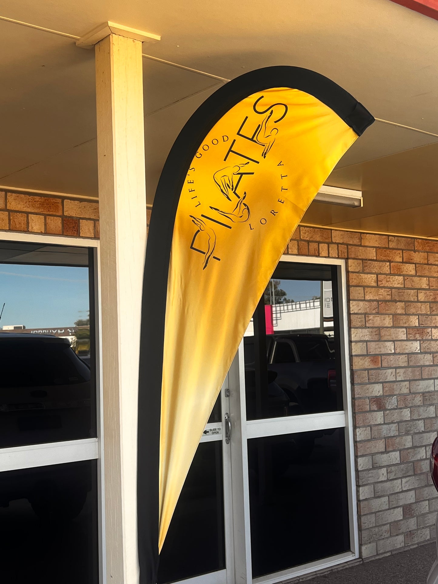 Gold and black teardrop banner with text hanging above a door