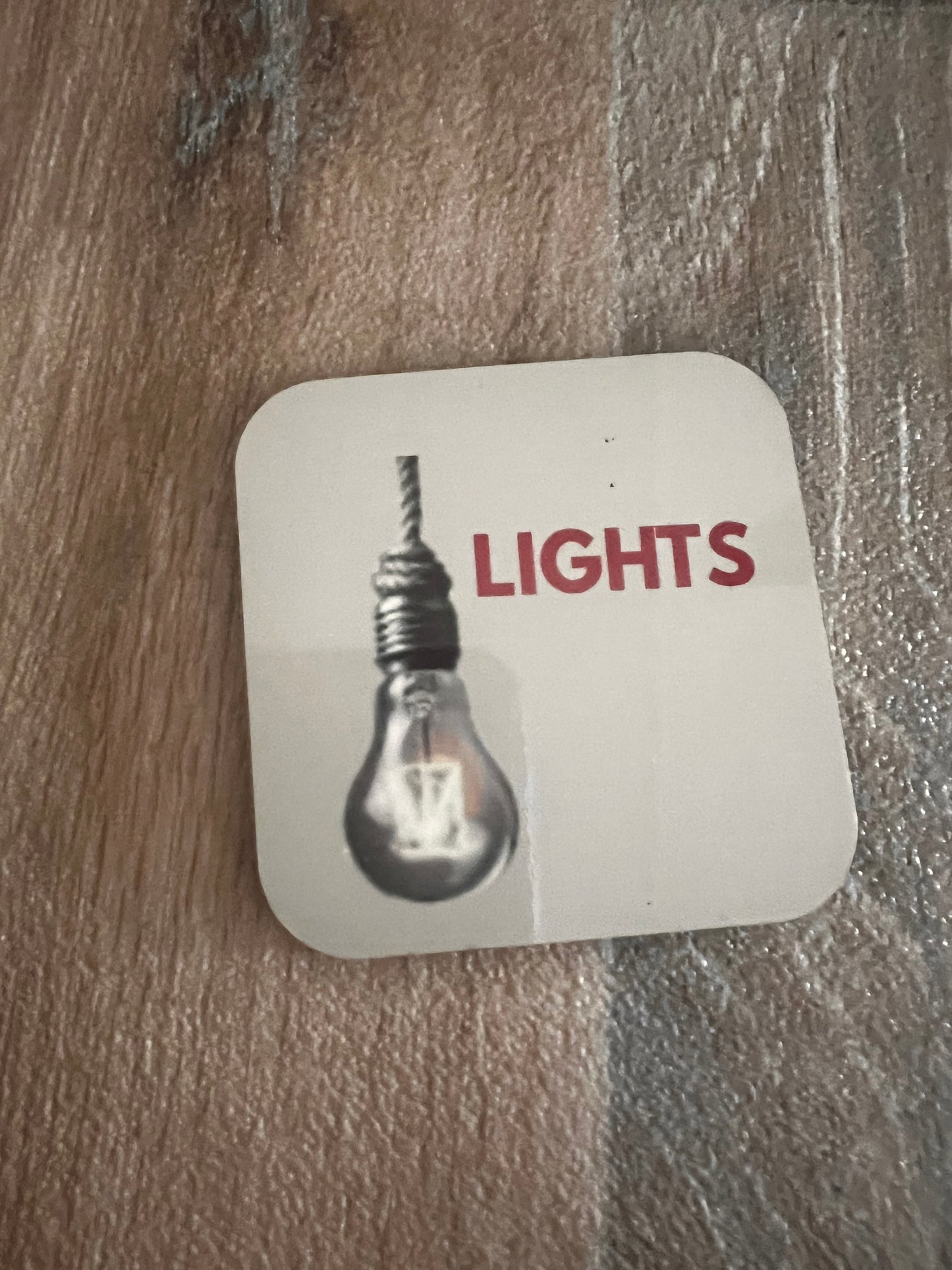 anxiety magnet with light bulb design and 'LIGHTS' text on a wooden surface