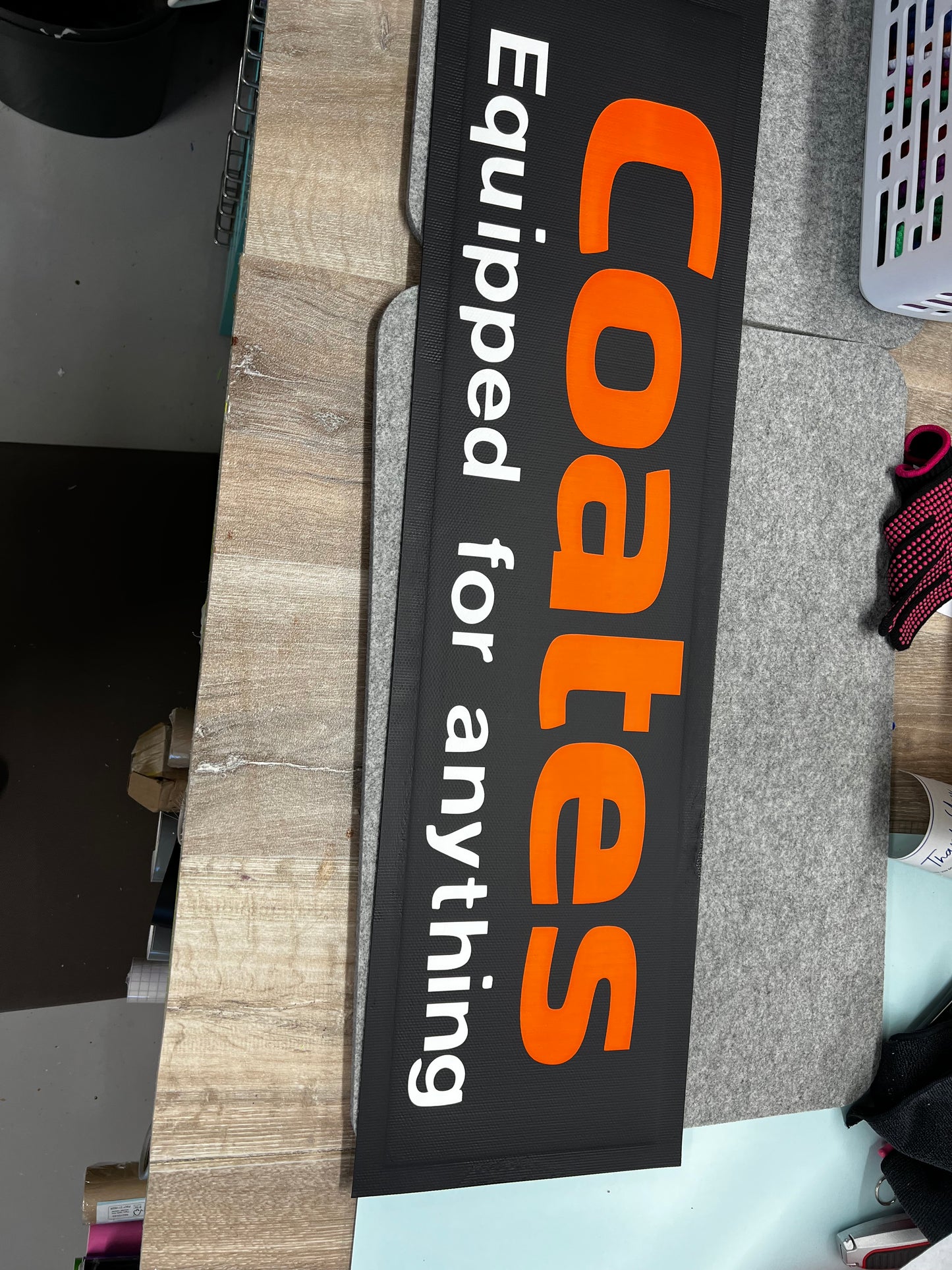 Coates branded mat with text 'Equipped for anything' on a wooden surface
